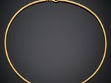 a gold necklace on a black background