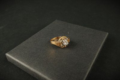 gros plan d'une bague en or sur une surface noire