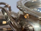 a silver bowl with a handle on a table