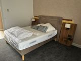 a bed that is made up in a room with carpet
