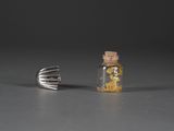 une petite bouteille de liquide posée à côté d'une fourchette sur une table
