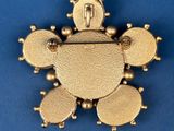an image of a gold broochle with a clock on top of it