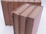 three books stacked on top of each other on a white surface
