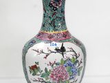 un vase avec un oiseau posé sur une table