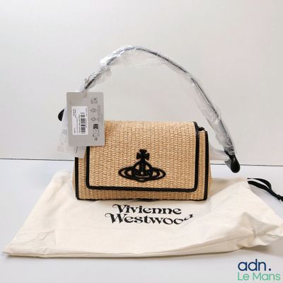 someone is holding a purse with a crown on it on a table