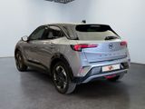 the rear end of a silver car in a showroom