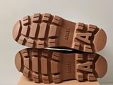 the soles of a pair of brown shoes on top of a cardboard box