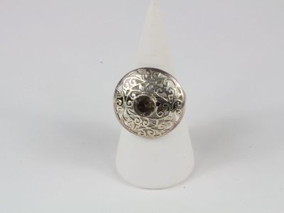 un gros plan d'une bague en argent sertie d'une pierre marron