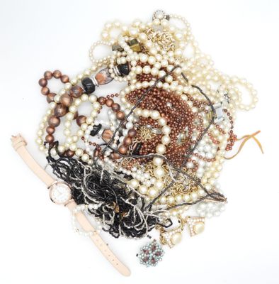 a pile of pearls and other jewelry on a white surface