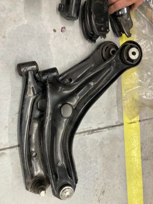 Quelqu'un est en train de travailler sur la suspension avant d'une voiture, allongé par terre.
