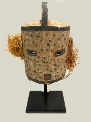 an image of a wooden mask with a face made out of straw