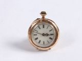 a small gold pocket watch with roman numerals on it