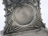 a silver plate with a bird on it sitting on a stand