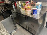 a stainless steel counter with a bunch of cleaning supplies on it