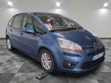 the small blue car is parked on a checkered tile floor