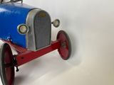 a blue and red toy car sitting on a white surface