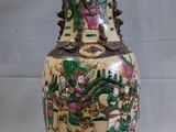 un vase avec un tableau posé sur une table