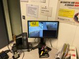 a desk with a computer monitor and a cell phone on it