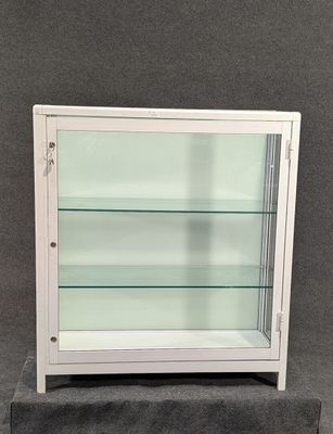 une vitrine blanche surmontée d'étagères en verre