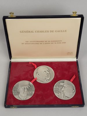 trois médailles commémoratives dans un coffret rouge orné d'un ruban rouge