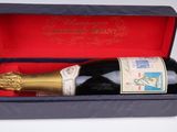 une bouteille de vin dans un carton sur lequel est apposé un timbre