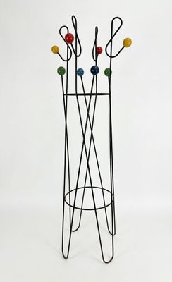 a metal coat rack with a bunch of coat hooks on it