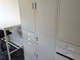 cabinets and a desk in an office with a chair in front of it