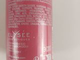 a close up of a bottle of red liquid on a white surface