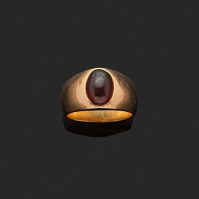 une bague ovale en or sertie d'une pierre de type grenatite