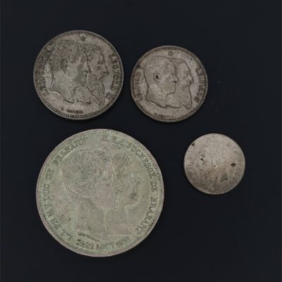 three silver coins are shown on a black surface
