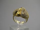 une photo d'une bague en or et diamants posée sur un socle transparent