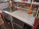 a man standing in a kitchen next to a sink