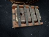 a piece of wood with a knife on it next to a suitcase