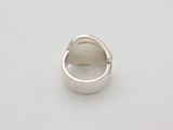 a close up of a silver ring on a white surface