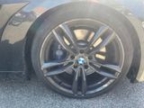 the wheel of a black bmw car with a blue bmw emblem on it