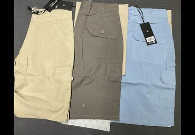 three pairs of men ' s cargo shorts with tags on them