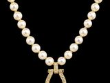 un collier de perles et de diamants orné d'un pendentif en forme de fer à cheval