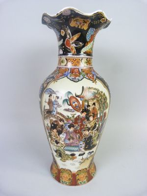 a vase with a painting on it sitting on a table