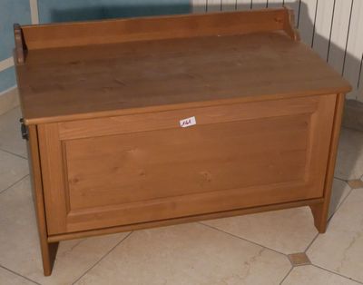 un banc en bois sur lequel est posée une pancarte, dans une pièce