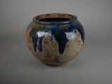 un vase bleu et marron posé sur une table