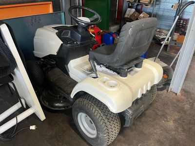 a white lawn mower parked in a garage