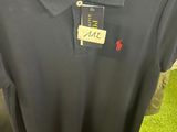 black polo shirt on display in a store with a price tag
