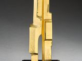 sculpture of a golden sculpture on a wooden base on a gray surface