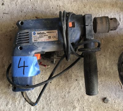 a drill that is sitting on the floor next to a cord