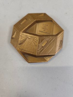 une plaque en or sur laquelle est représenté un bâtiment
