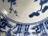 a close up of a blue and white plate with flowers