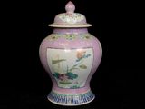 a pink vase with a lid on a black background