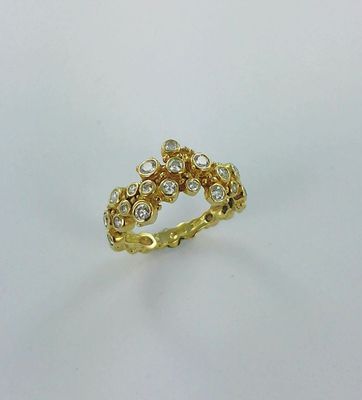 gros plan d'une bague en or et diamants sur une surface blanche