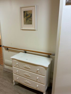 une commode blanche dans un coin de la pièce