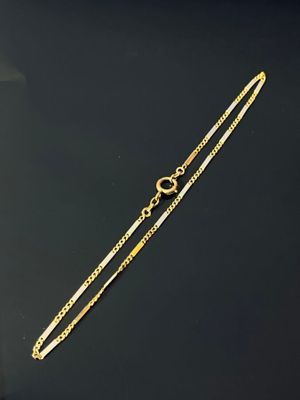 a close up of a gold chain on a black surface